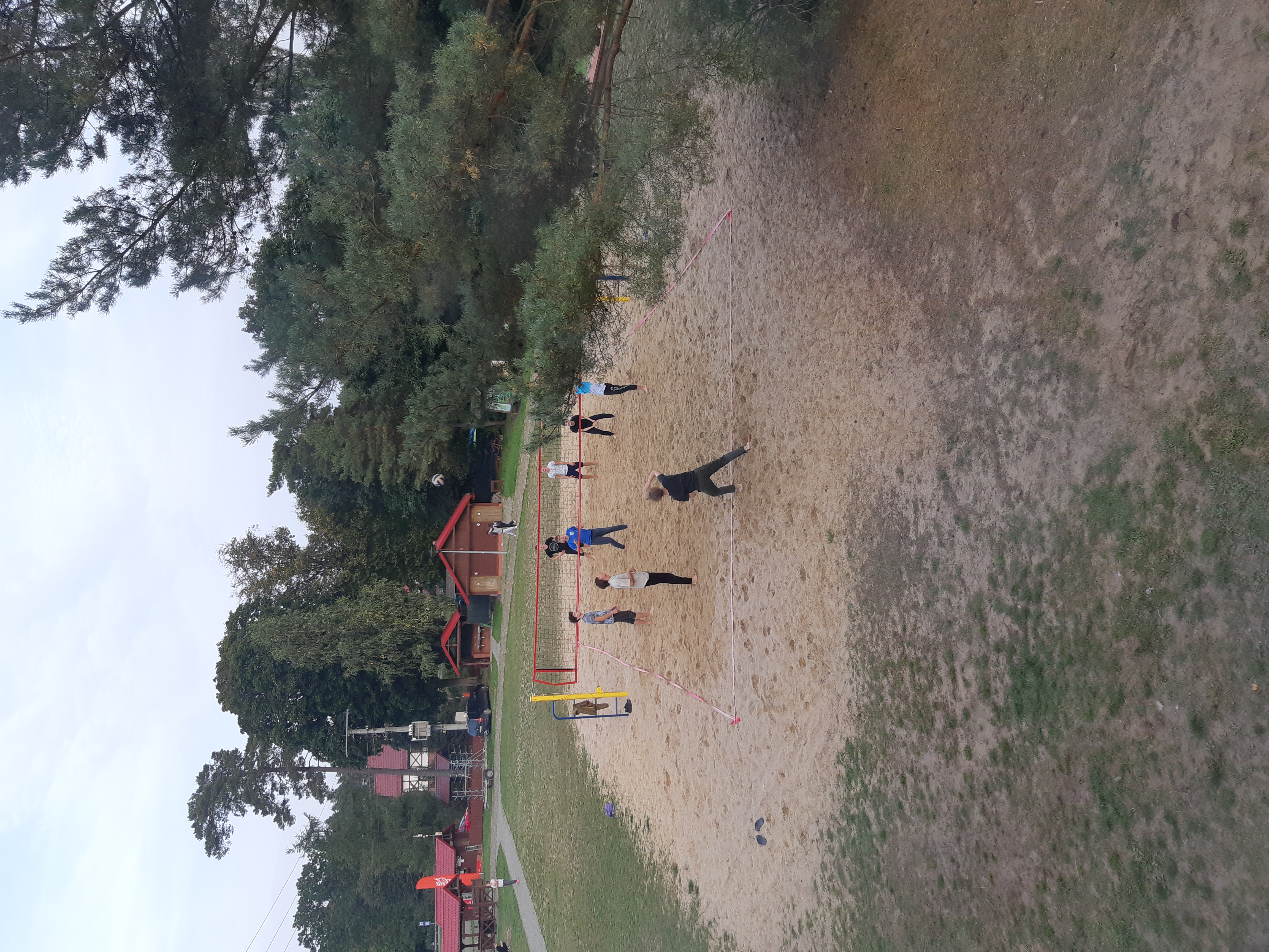 Zdjęcie uczniów grających w siatkówkę na boisku na terenie Zielonej Szkoły.